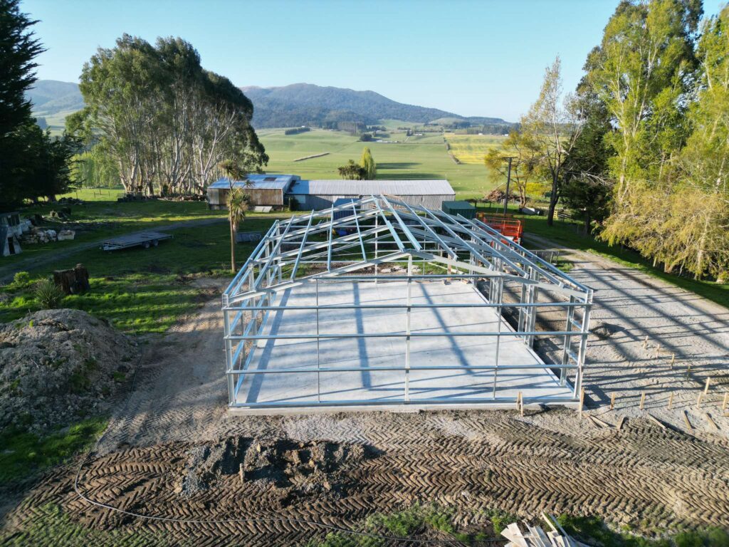 Titan kitset shed construction in New Zealand featuring structural steel framing, pre-engineered components, and Colorsteel cladding during on-site assembly.